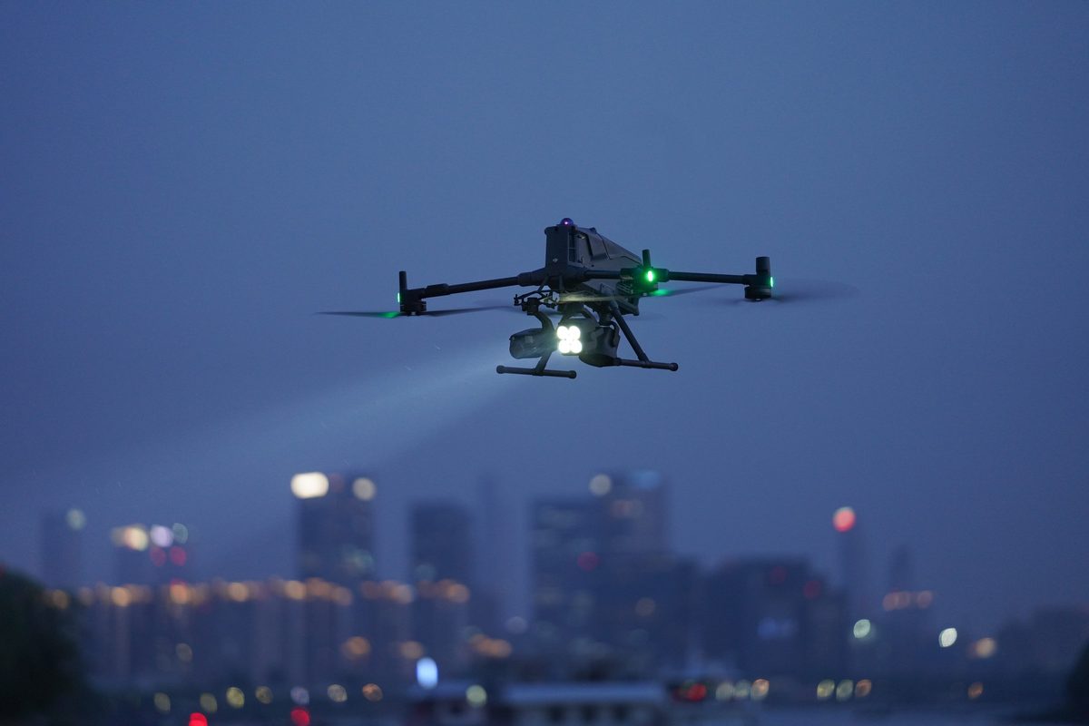 Dron s reflektorem při nočním obletu areálu