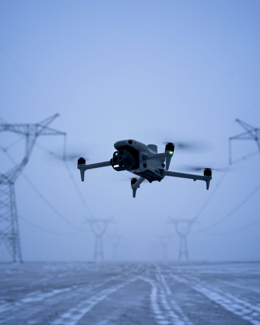 Dron při inspekci vedení vysokého napětí mezi stožáry